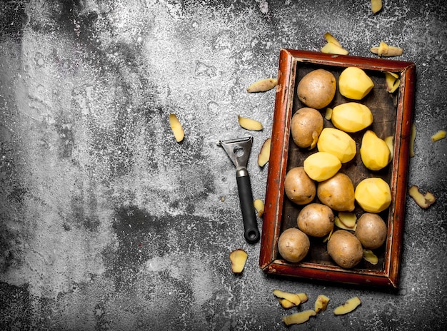 Verse aardappelen in een oud dienblad op rustieke tafel