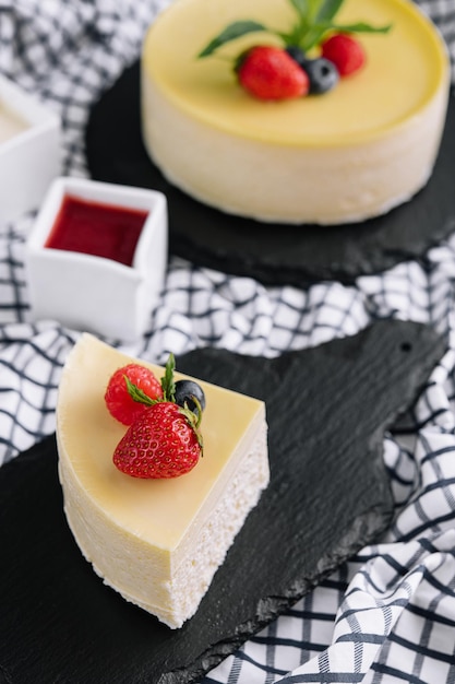 Verse aardbeien cheesecake op zwart dienblad