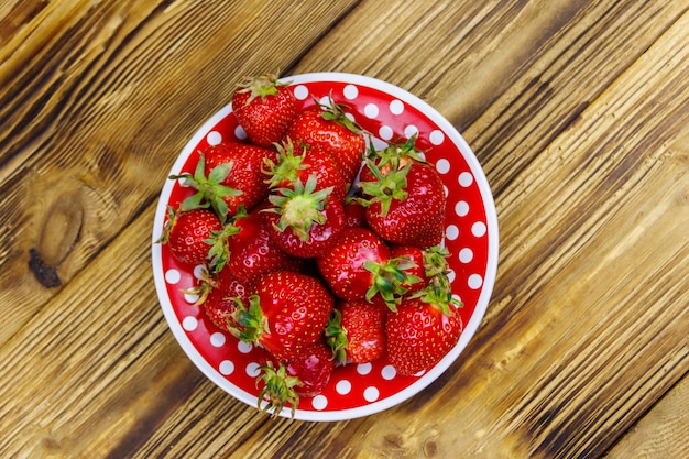 Verse aardbeien in een bord op een houten tafel Bovenaanzicht