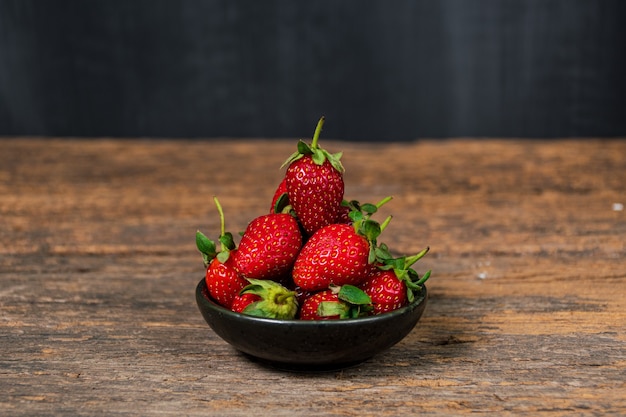 Verse aardbeien in een kom op houten tafel met rustige scène Aardbei met witruimte