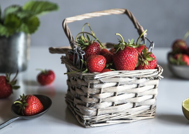 Verse aardbeien in een mand op een witte houten tafel