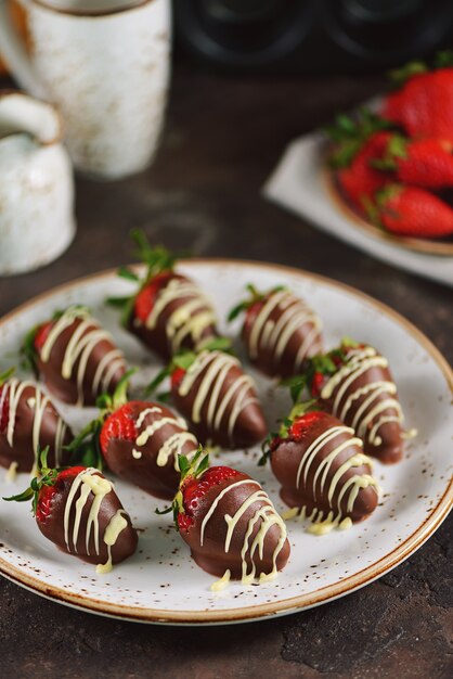 Verse aardbeien in melkchocolade en witte chocolade