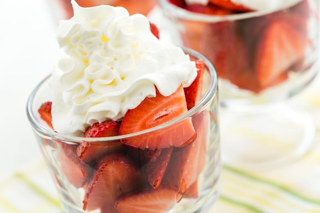 Verse aardbeien met slagroom in glazen kommen crème voor het dessert.