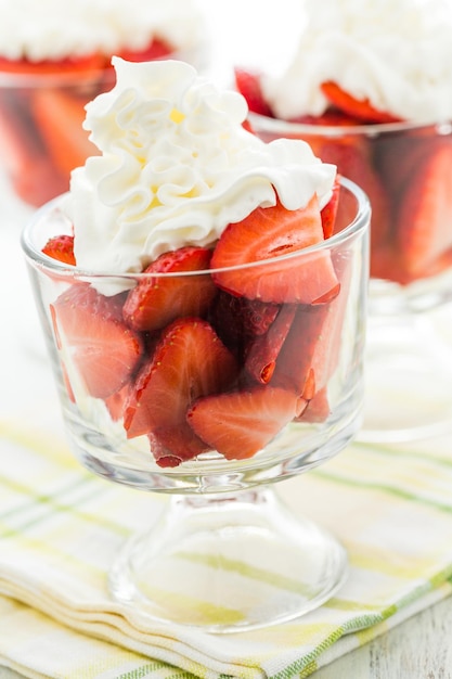 Verse aardbeien met slagroom in glazen kommen crème voor het dessert.