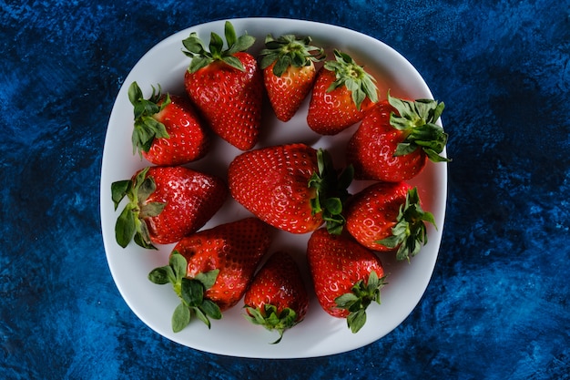 Verse aardbeien op een blauwe gestructureerde basis