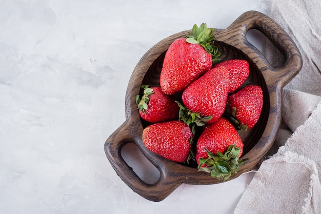 Verse aardbeien op houten plaat op witte lijstachtergrond