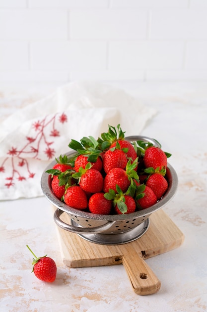 Verse aardbeien rijp heerlijk in vergiet kom op witte stenen tafel