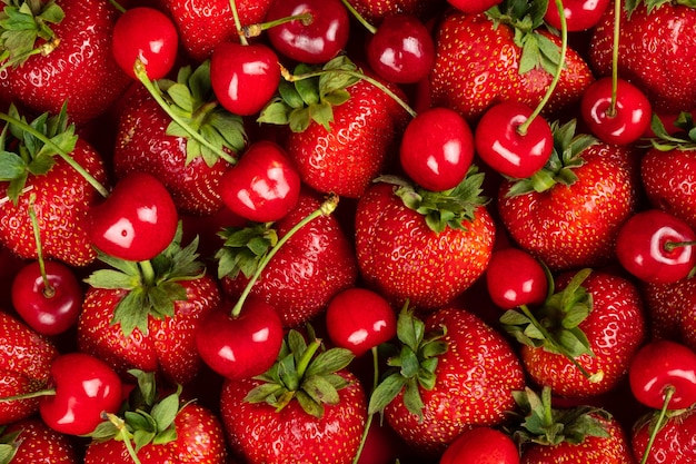 Verse achtergrond, vers geplukte aardbeien en kersen, achtergrond met seizoensgebonden bessen en fruit.