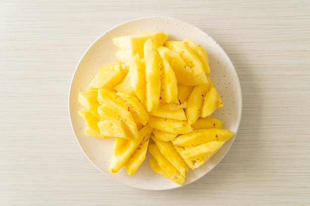 Verse ananas gesneden op witte plaat