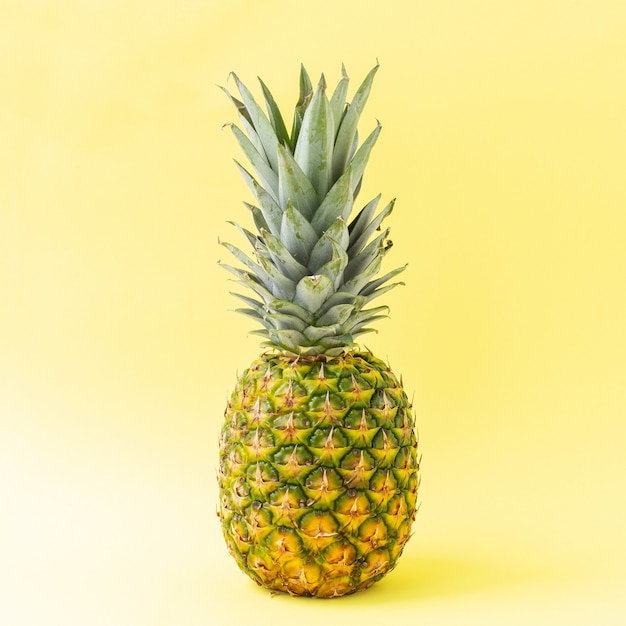 Verse ananas op gele achtergrond.