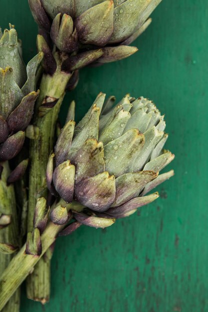 Verse artisjok op groene achtergrond Rauwe artisjokken close-up