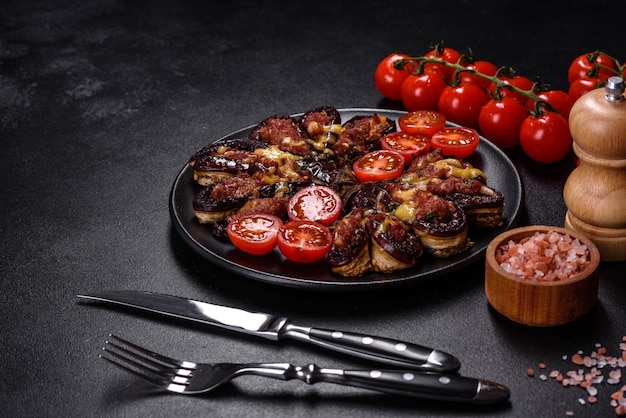 Verse aubergine gebakken met gehaktkruiden en kruiden op een zwarte plaat