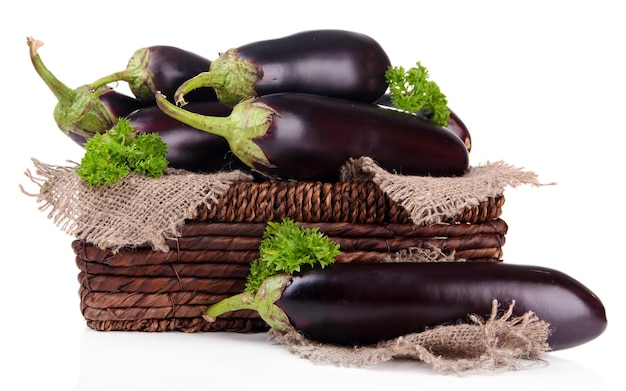 Verse aubergines in rieten mand geïsoleerd op wit