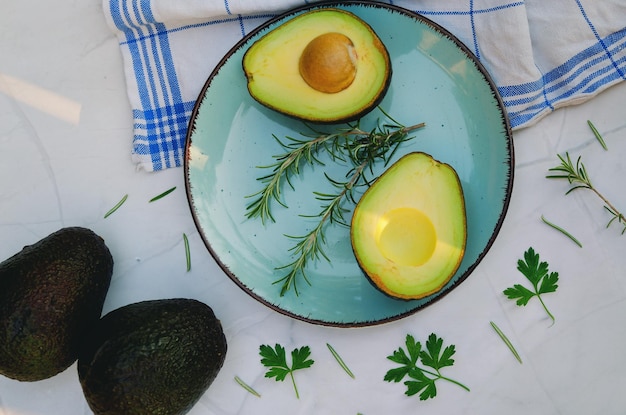 Verse avocado met kruiden en citroenen ligt prachtig op tafel op blauw bord. Plat leggen. Bovenaanzicht