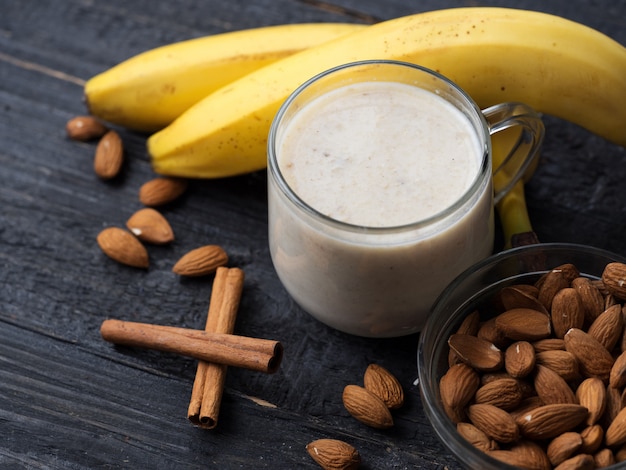 Verse banaan smoothie met amandelen op een houten achtergrond