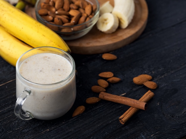 Verse banaan smoothie met amandelen op een houten achtergrond