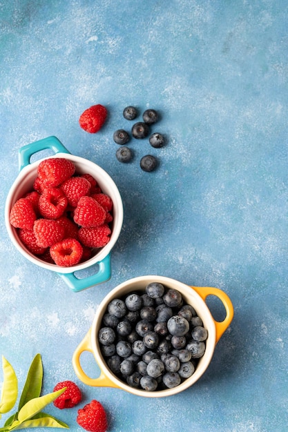 Verse bessen bosbes en framboos in keramische kommen kleurrijke fruit eten achtergrond bovenaanzicht