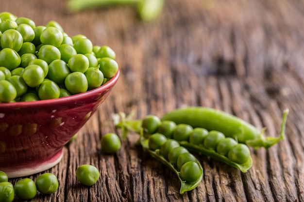 Verse bio zelfgemaakte erwten en peulen op oud eiken bord Gezonde verse groene groenteerwten en peulen