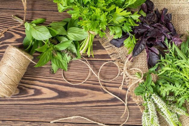 Verse biologische groene kruiden houten vloer met kopie ruimte Groene en violette planten achtergrond Gezond eten achtergrond Vegetarische voeding biologisch voedsel