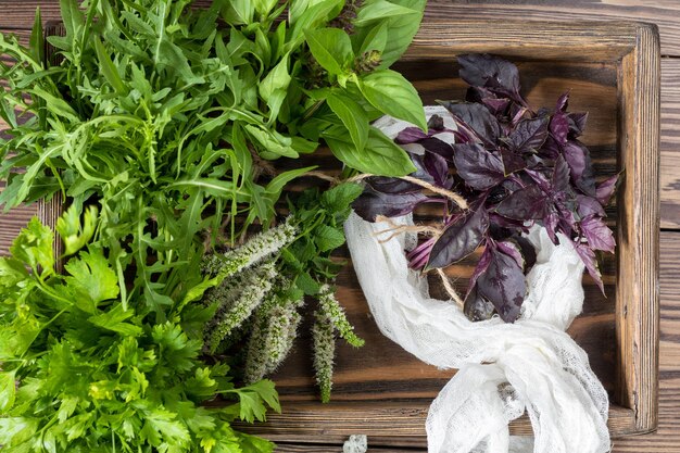 Verse biologische groene kruiden houten vloer met kopie ruimte Groene en violette planten achtergrond Gezond eten achtergrond Vegetarische voeding biologische voeding