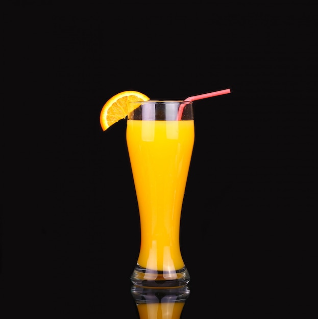 Verse biologische sinaasappelsap en wodka in een hoog glas op zwart