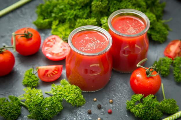 Verse biologische tomaten en tomatensap met peterselie. het detox-concept.