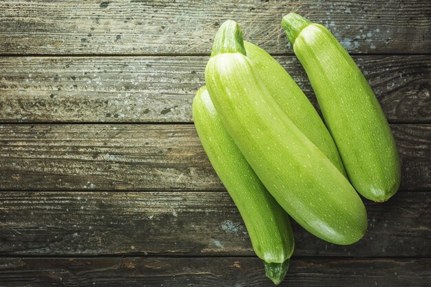 Verse biologische zomer groenten courgette op rustieke houten achtergrond. Bovenaanzicht, ruimte voor tekst.