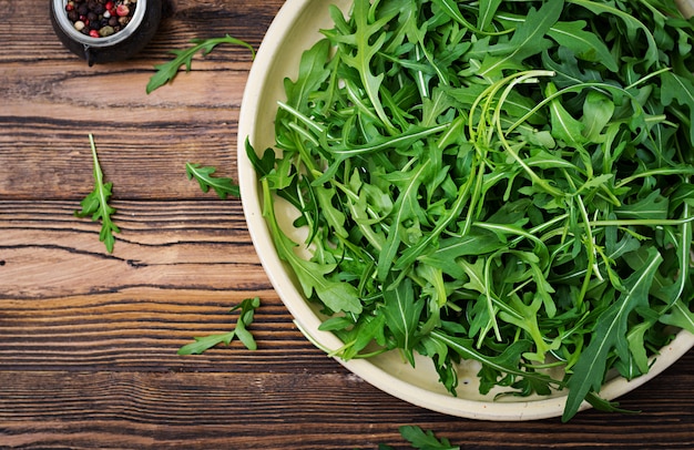 Verse bladeren van rucola in een kom. Plat leggen. Bovenaanzicht