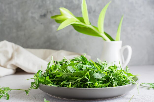 Verse bladeren van rucola op een bord op tafel. Biologisch dieet vegetarisch eten. Levensstijl. Ruimte kopiëren