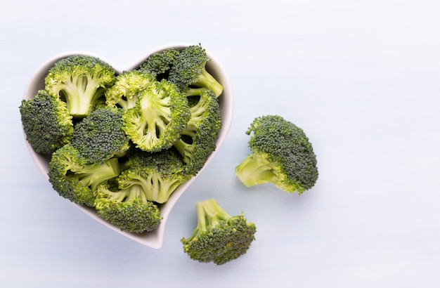 Verse broccoli in een hartvormige kom op een houten tafel