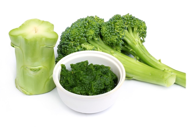 Verse broccoli met gemalen pasta op witte achtergrond