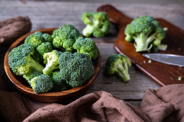 Verse broccoli met houten snijplank op oude houten tafel