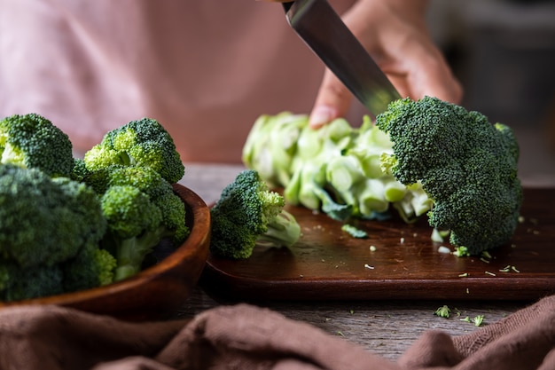 Verse broccoli met houten snijplank op oude houten tafel