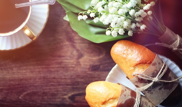 Verse broodjes voor het ontbijt. Broodje met boter tot een kopje koffie in de ochtend. Ontbijt in het hotel broodjes jam thee en een boeket bloemen.