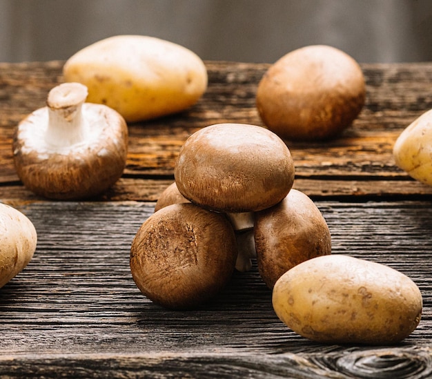 Verse bruine champignonschampignon klaar om te koken op een oude houten tafelaardappel