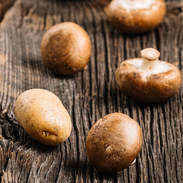 Verse bruine champignonschampignon klaar om te koken op een oude houten tafelaardappel