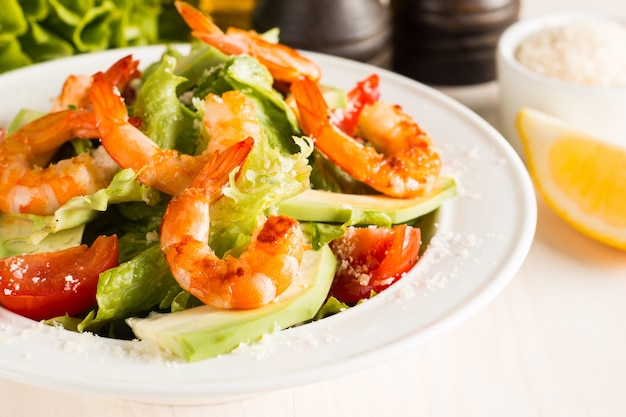 Verse Caesar-garnalensalade met heerlijke garnalen, rucola, spinazie, kool, rucola, ei, parmezaanse kaas en kersentomaat Gezond en dieetvoedselconcept.