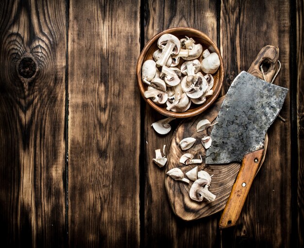 Verse champignons gesneden grote oude bijl. Op houten tafel.