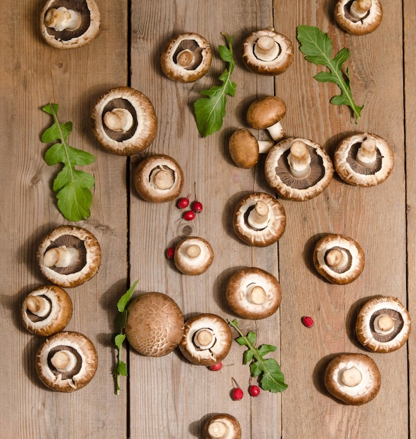 Verse champignons met bladeren van rucola op houten achtergrond