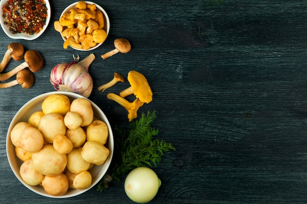 Verse champignons met specerijen en kruiden op zwarte bord