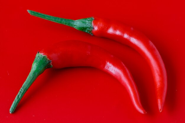 Verse chili peper op effen rode achtergrond