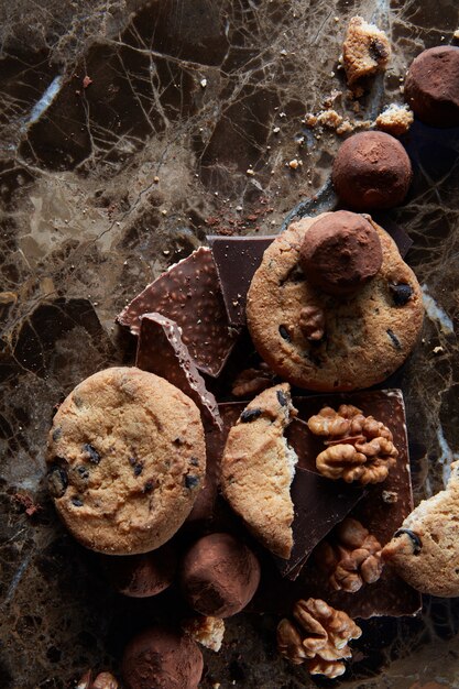 Verse chocoladeschilferkoekjes met chocoladesuikergoed in het donkere marmeren oppervlak.