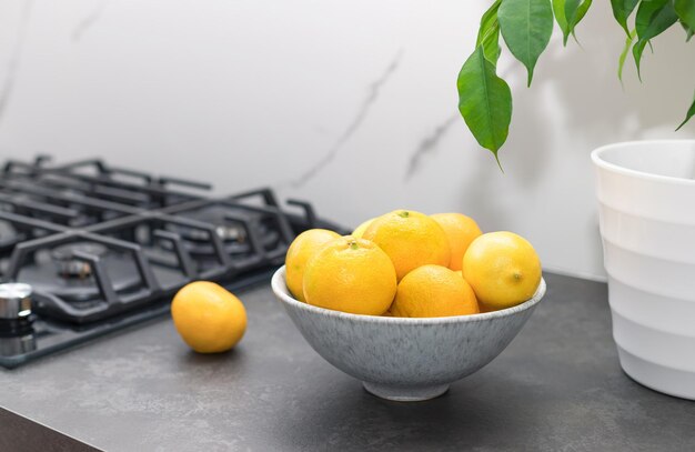 verse citrusvruchten in keramische kom op aanrecht in de keuken bij modern huis gezond vitaminevoedsel