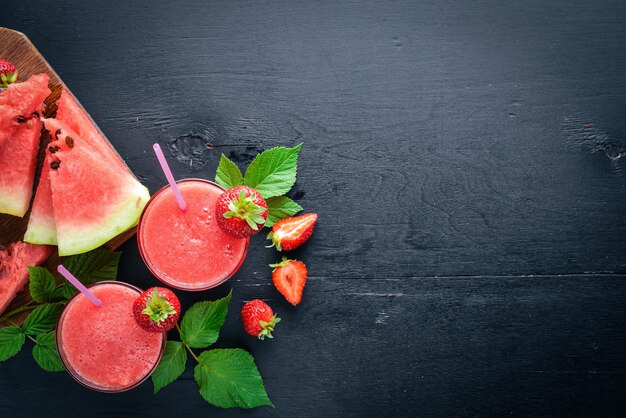 Verse cocktail van watermeloen en aardbeien muntijs op een houten plank bovenaanzicht vrije ruimte voor uw tekst