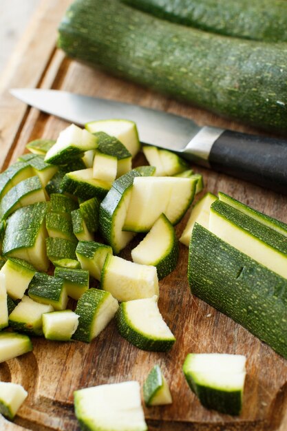 Verse courgette op een houten bord met een mes