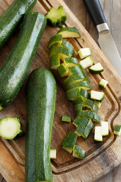 Verse courgette op een houten bord met een mes