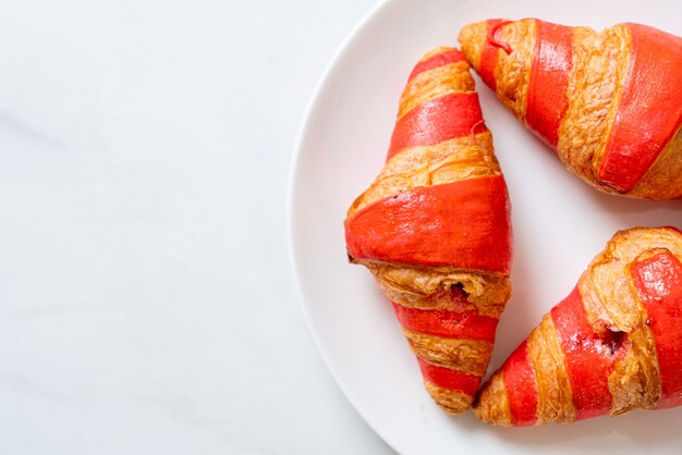 Verse croissant met aardbeienjam saus op plaat