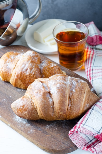 Verse croissant met thee voor het ontbijt. Eten fotografie.