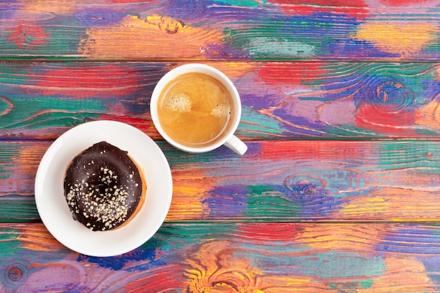 Verse doughnut met koffie op houten oppervlakte