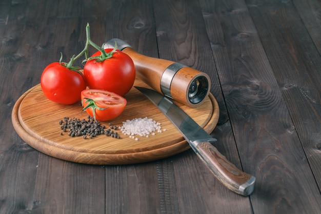 Verse druiventomaten en grof zout voor gebruik als kookingrediënten met een gehalveerde tomaat